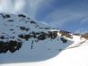 Looking back up from the lochan.  Spot the skier in the short gully below the ridge (in the sunlight)  Photo: Scott Muir